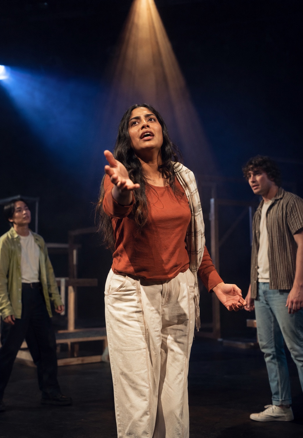 Student performer delivering a musical-theatre scene under stage lights