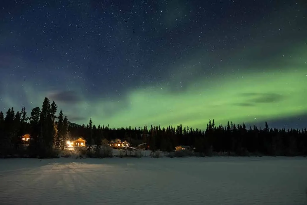 Northern lights above a snowy Yukon landscape