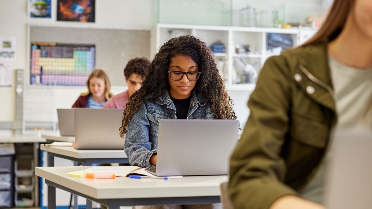 student working on laptop in class